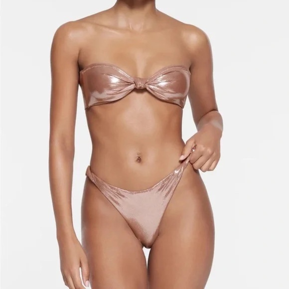 SKIMS LIQUID SHINE SWIM KNOTTED CHEEKY TANGA BOTTOM in Cinnamon. - Picture 3 of 3